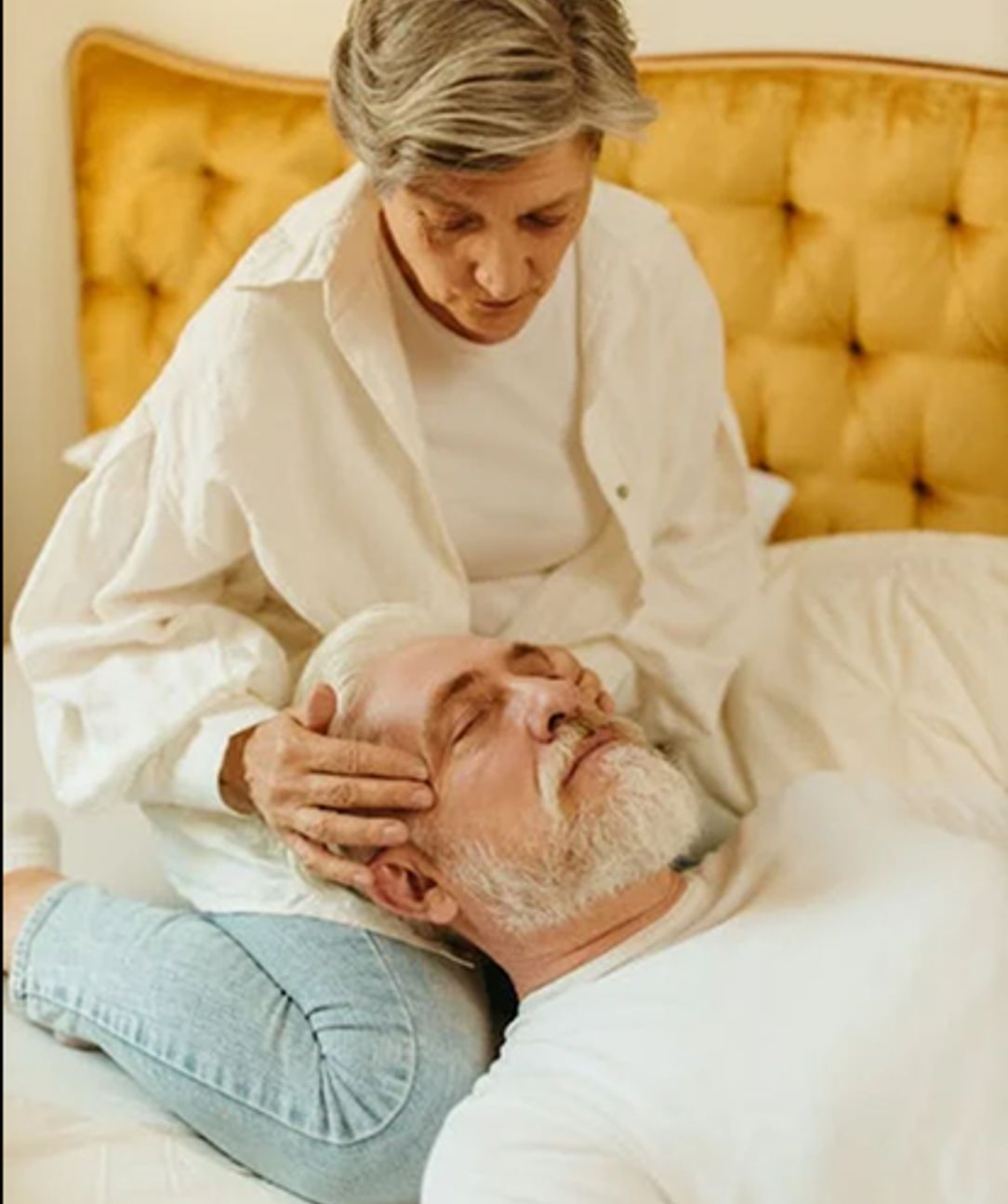 An older man receiving a head massage from a woman